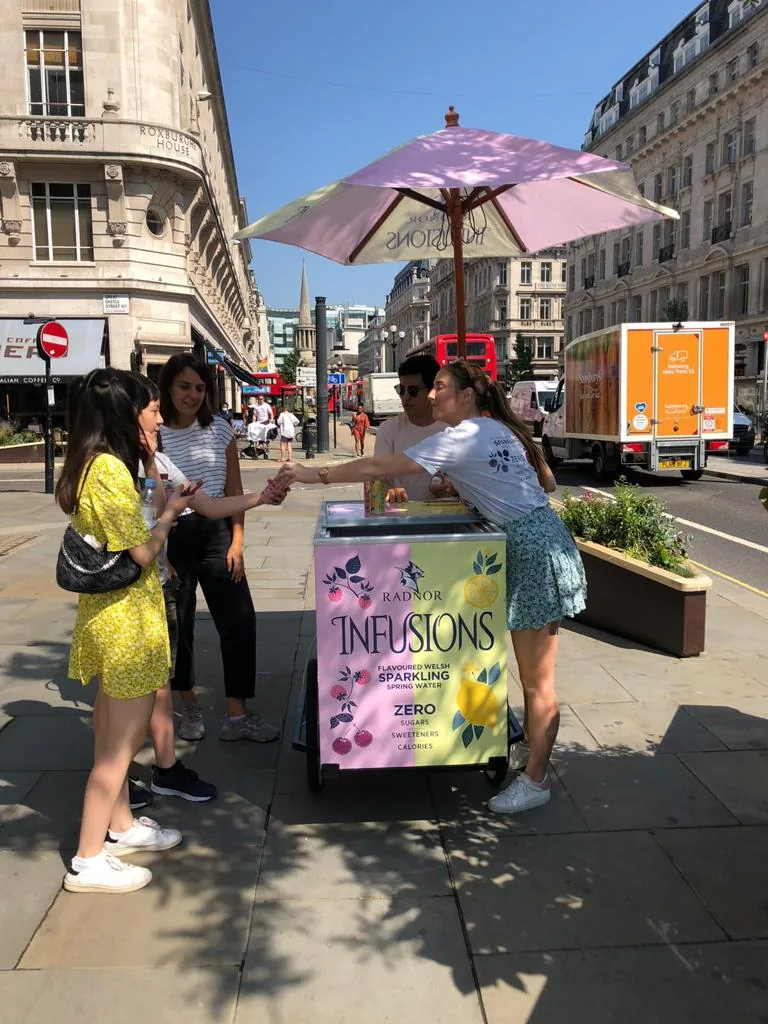 FOTS ambassador serving Radnor Infusions sparkling spring water from the branded sampling trike on a central London street