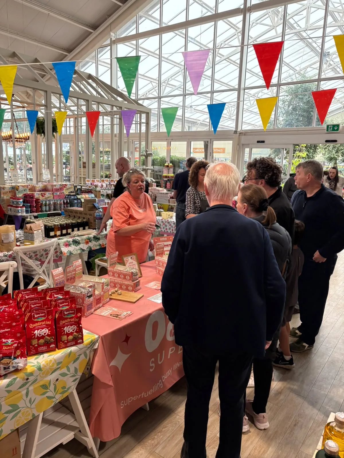 FOTS ambassador talking shoppers through Oatco Superfuel products at a busy garden centre sampling table
