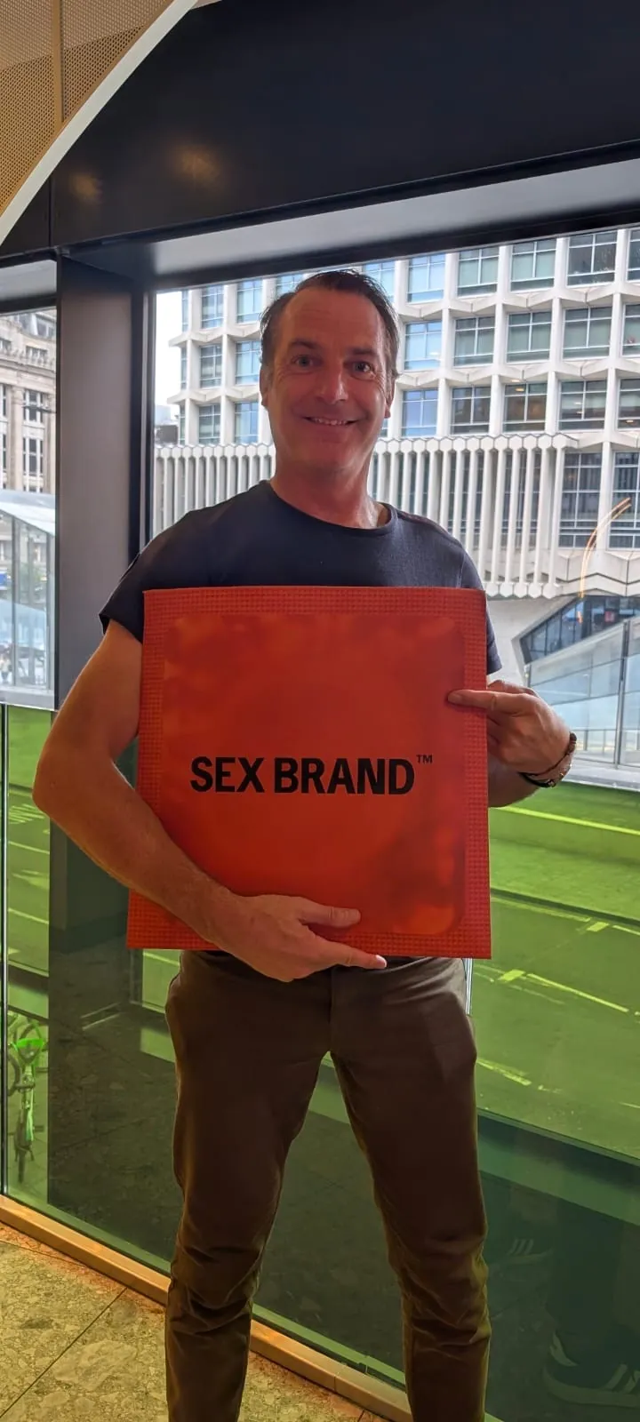Recipient holding a bespoke Sex Brand product seeding box in a London office