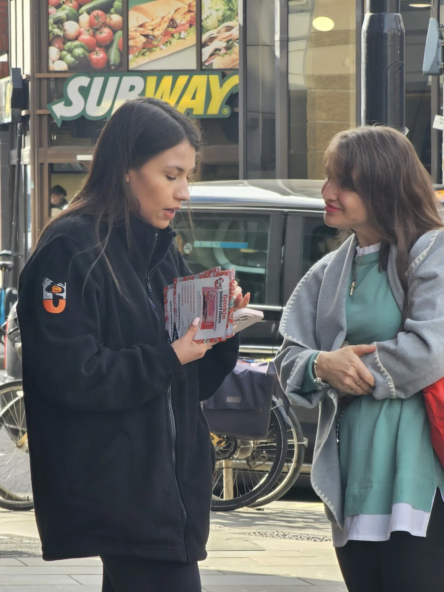 FOTS ambassador talking a shopper through Datelkin Sukkari dates leaflets on a London street